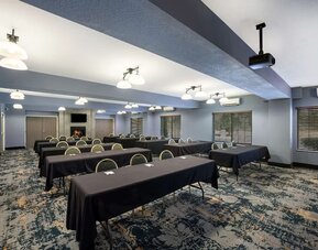 Conference room with rows of tables, chairs, and a presentation screen at Best Western Plus Mountain View Auburn Inn.