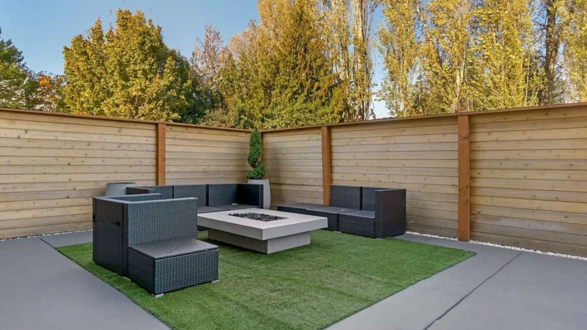 Outdoor patio with wicker seating, artificial turf, and a square fire pit at Best Western Plus Mountain View Auburn Inn.