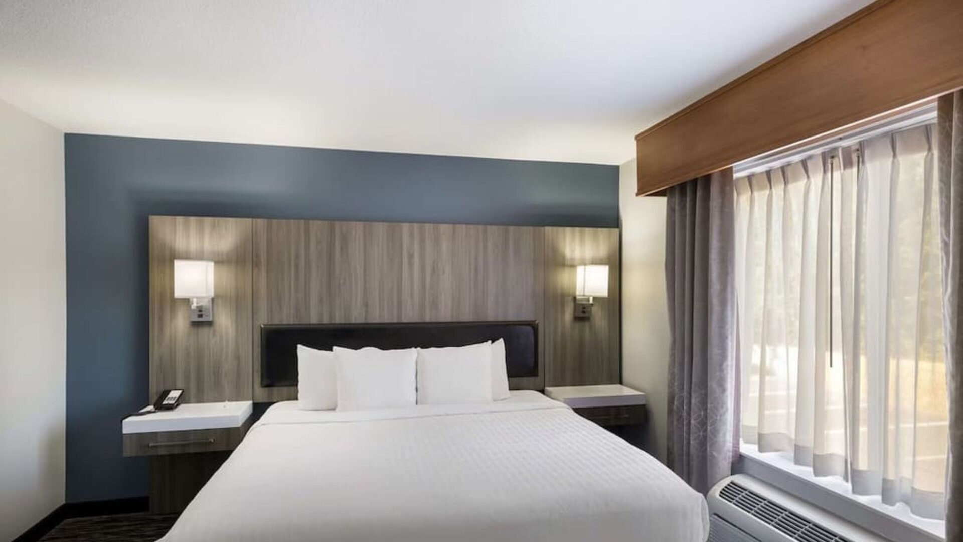 King guest room with large bed, bedside lighting, desk, and window at Best Western Plus Mountain View Auburn Inn.