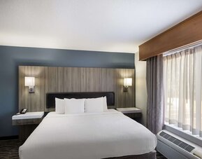 King guest room with large bed, bedside lighting, desk, and window at Best Western Plus Mountain View Auburn Inn.