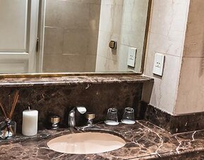 Bathroom vanity with marble countertop, oval sink, large mirror and toiletries at Ramada by Wyndham Buenos Aires Centro.