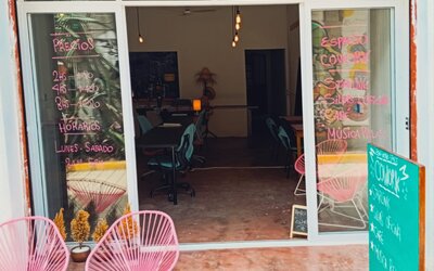 Entrance of the CoWork Zipolite cafe' with pink acapulco chairs at the entrance and a door to make the space more comfortable and sound-proof.