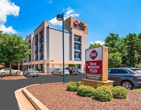 Exterior view of Best Western Plus BWI Airport Arundel Mills, showing the hotel building, branded roadside sign, landscaped grounds, and parking area in daylight.