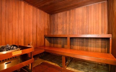 Wooden sauna room with timber walls, built-in benches, and an electric sauna heater at Best Western Plus BWI Airport Arundel Mills.