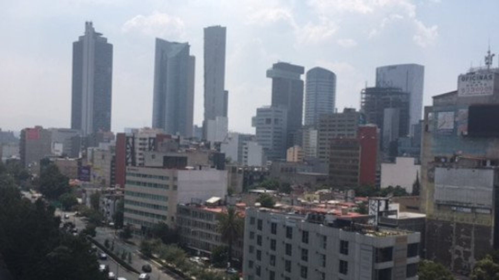 Daytime cityscape featuring high-rise office buildings, commercial streets and distant skyline views at Hotel Block Suites.