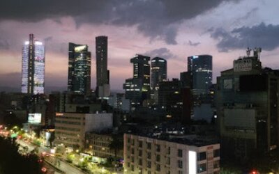 Panoramic nighttime view of Mexico City’s illuminated skyline and busy streets at Hotel Block Suites.