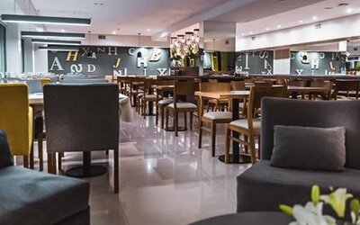 Dining area with tables, upholstered chairs, pendant lighting and polished floors at Howard Johnson Plaza Buenos Aires.