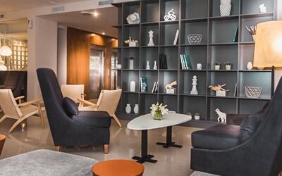 Hotel lobby with armchairs, coffee tables, decorative shelving and contemporary lighting at Howard Johnson Plaza Buenos Aires.