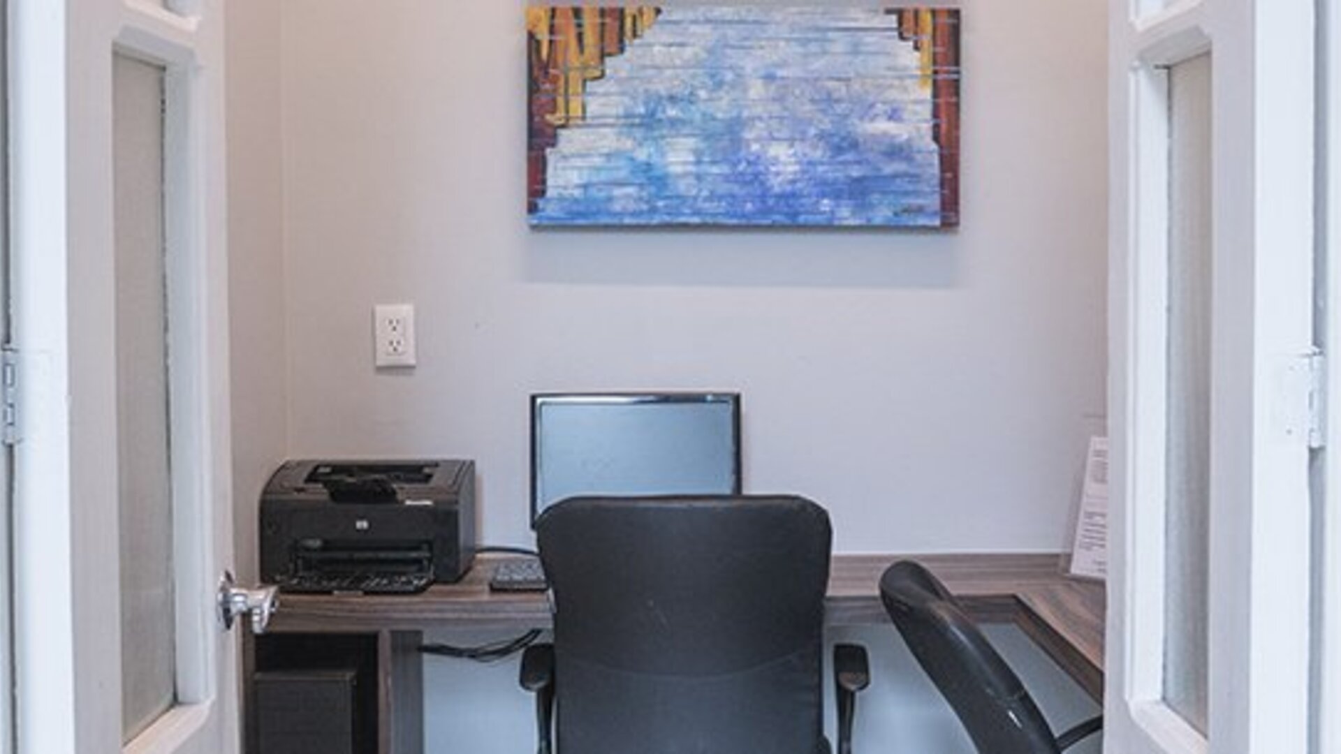 Business centre with a desk, computer, printer and office chair at Hotel Principal.