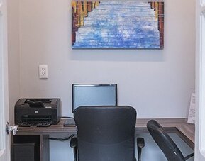 Business centre with a desk, computer, printer and office chair at Hotel Principal.
