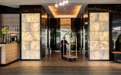 Hotel lobby entrance with illuminated stone columns, polished flooring and a luggage trolley at Hotel Las Américas Golden Tower Panamá.