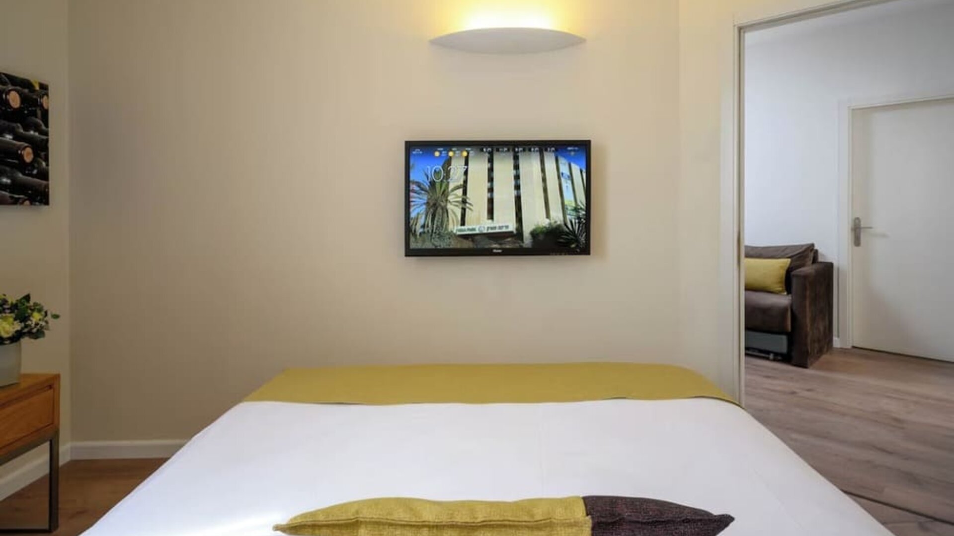 Close-up view of a neatly made king-size bed with white bedding, a gold bed runner, and contrasting decorative cushions at Prima Park Hotel.