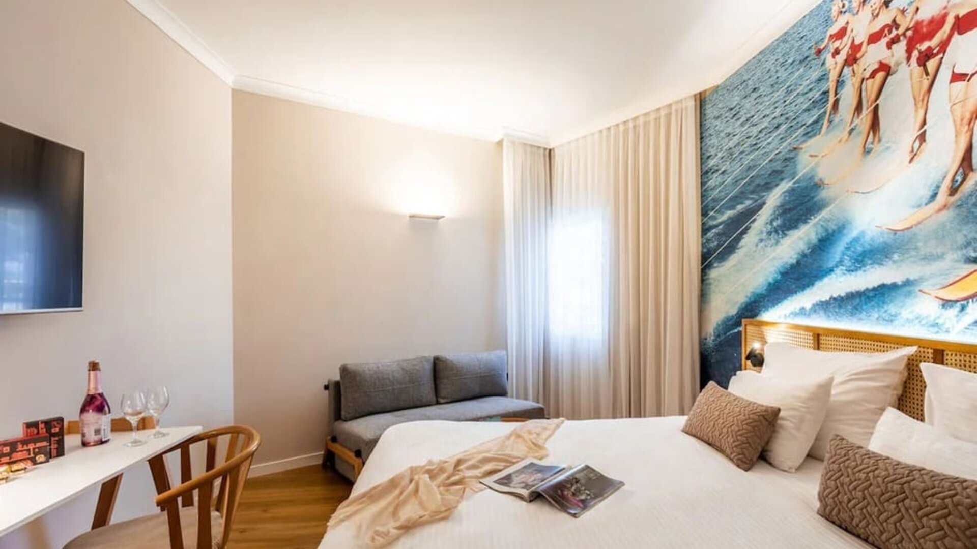 Guest bedroom with a double bed, white curtains and large windows providing natural light at Prima Music Eilat.