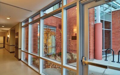 Interior corridor with full-height windows overlooking a landscaped courtyard at Hyatt Place Portland Airport at Cascade Station.