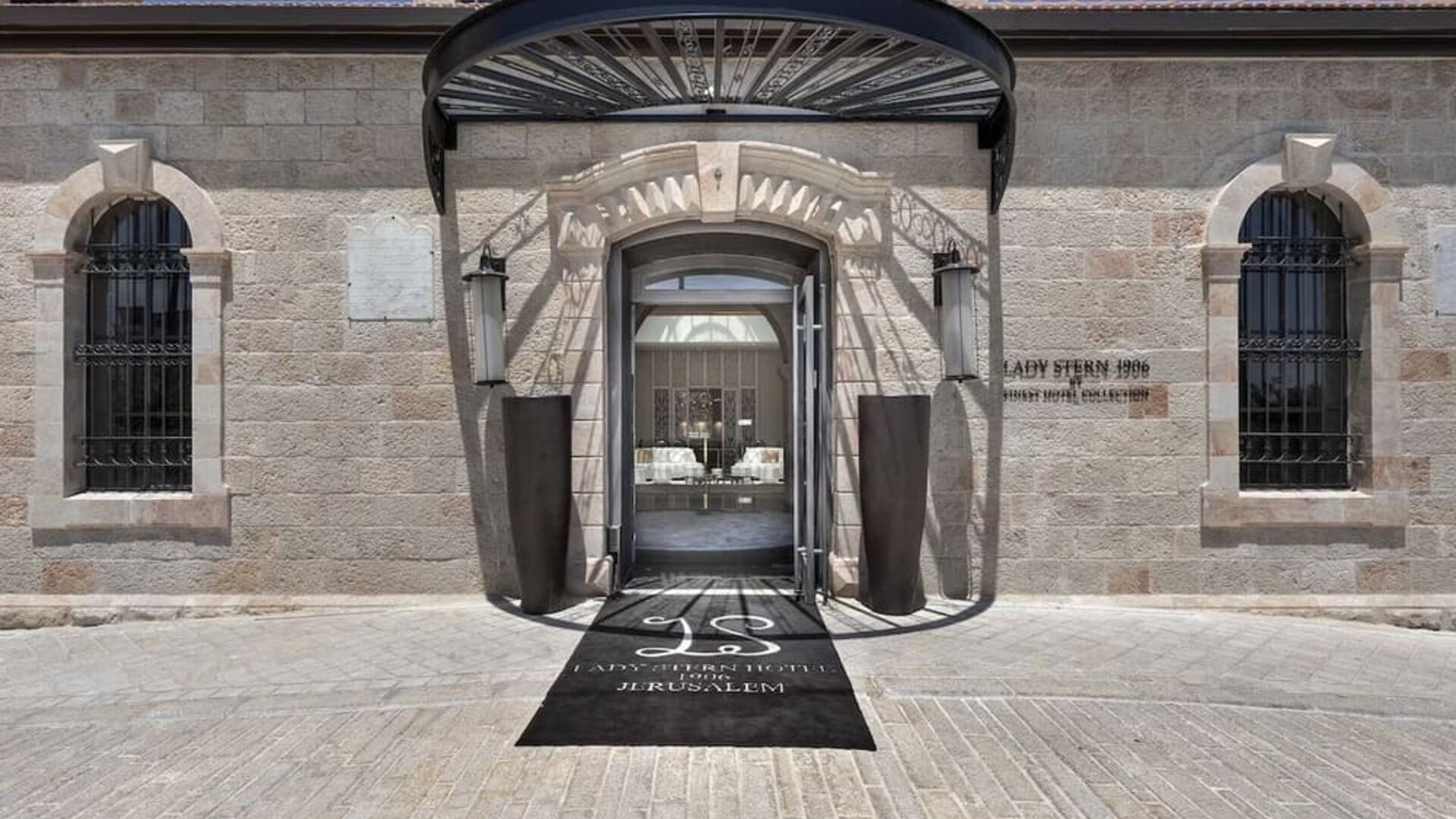 Main hotel entrance with stone façade, arched doorway and covered entrance canopy at Lady Stern Hotel.