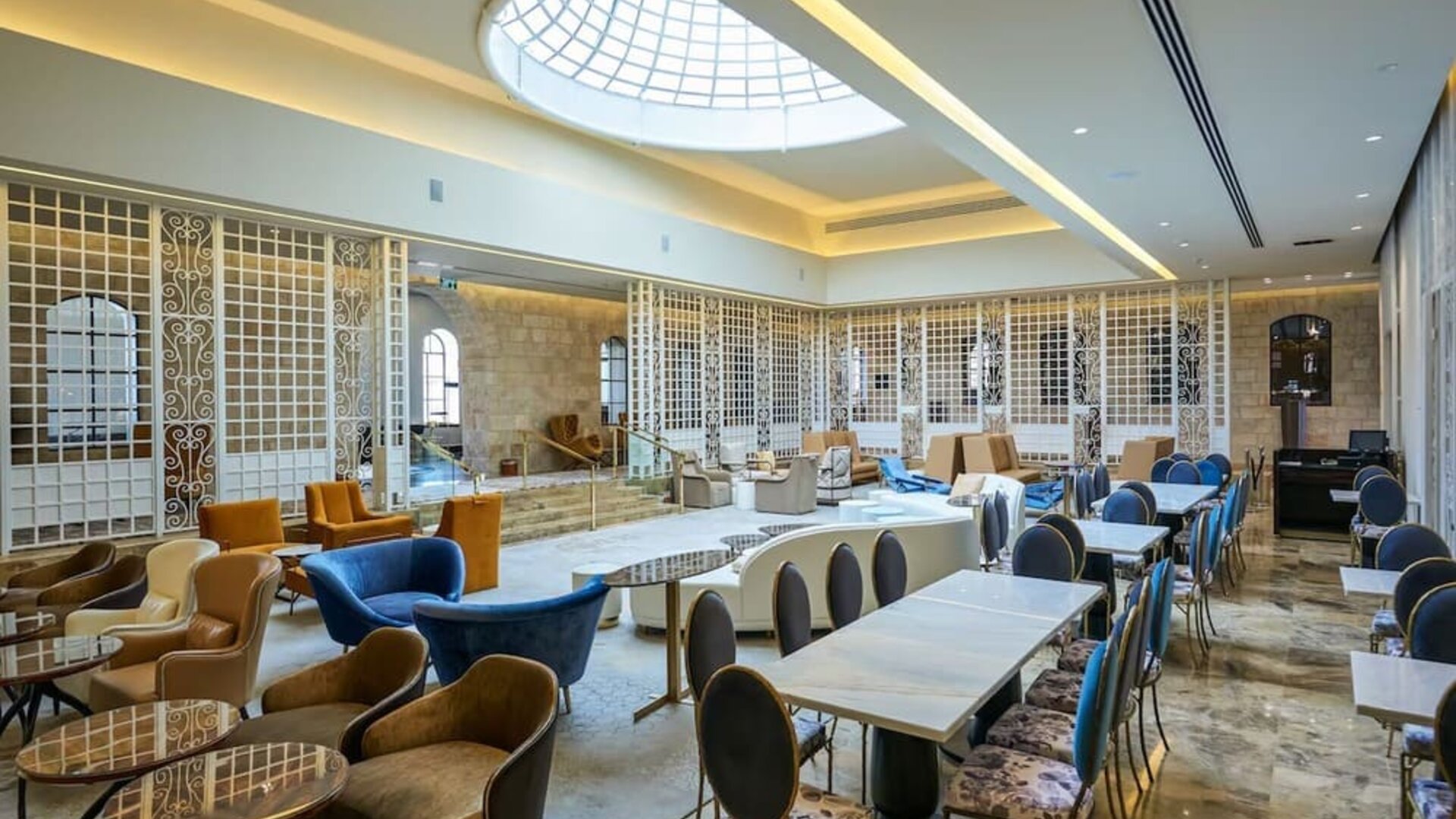 Dining area with tables, upholstered chairs and decorative lattice partitions at Lady Stern Hotel.