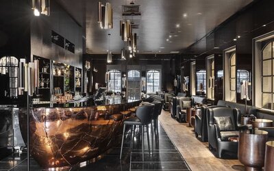 Hotel bar with dark marble counter, bar stools and leather lounge seating at Lady Stern Hotel.