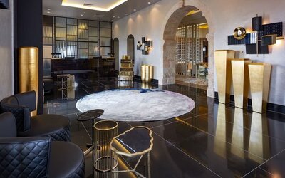 Concierge reception desk in a minimalist lobby with arched windows at Lady Stern Hotel.