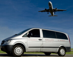 Silver Mercedes passenger van displaying hotel branding beneath a clear blue sky at Hotel Sallés Ciutat del Prat.