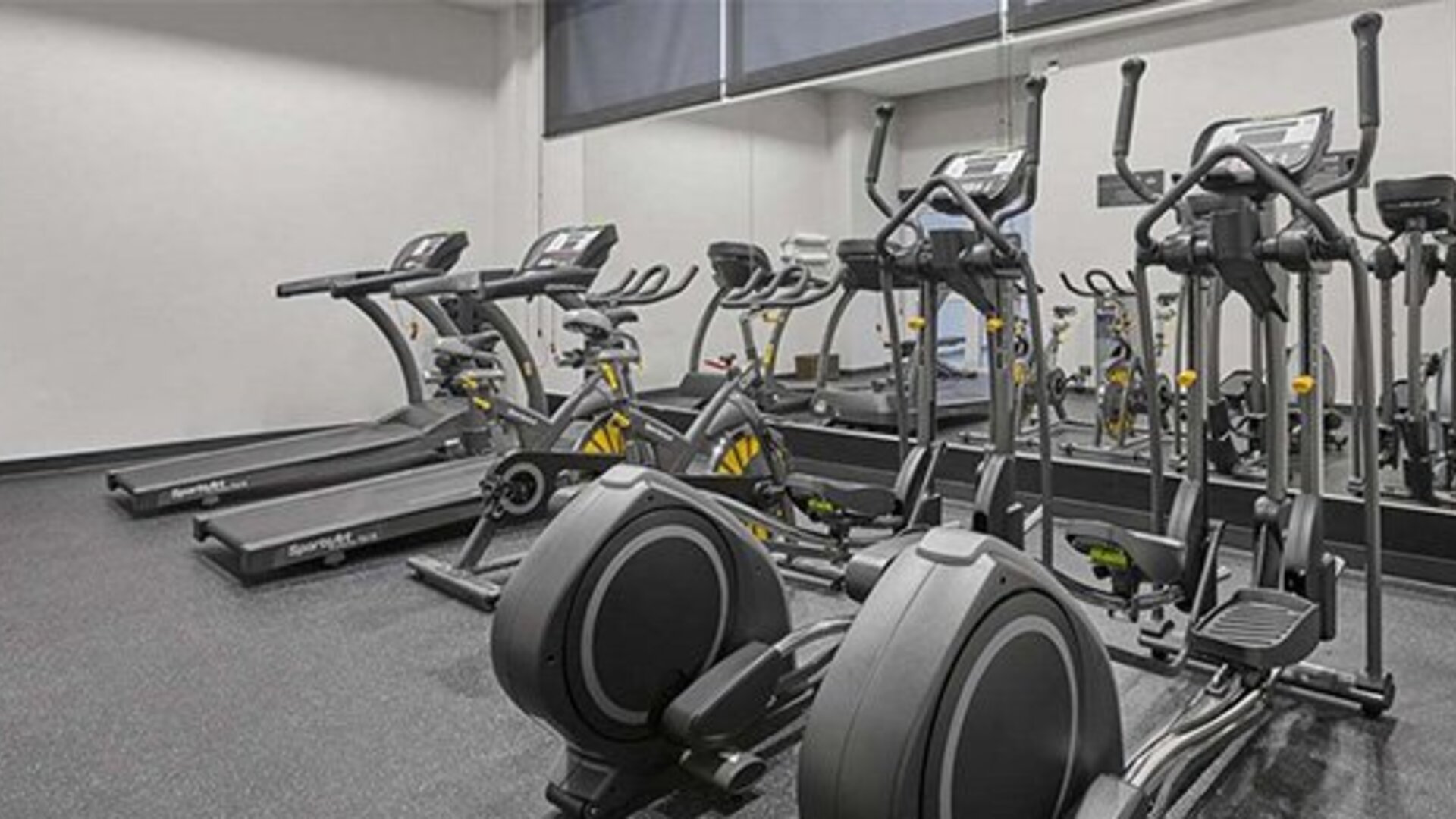 Fitness centre with treadmills, elliptical machines and exercise equipment arranged on a grey floor at City Express by Marriott CDMX La Villa.