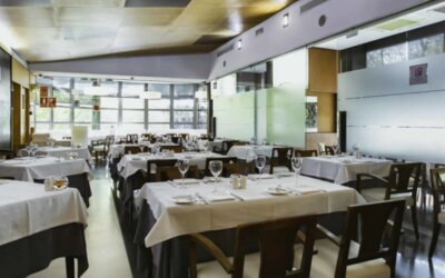 Restaurant dining room with white tablecloths, dark wooden chairs, glass walls and neatly arranged place settings at Hotel Best Western PLUS Alfa Aeropuerto.