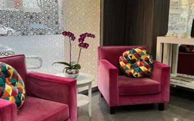 Lobby lounge with magenta armchairs, colourful cushions, purple orchids and patterned decorative panels at Ian Hotel.