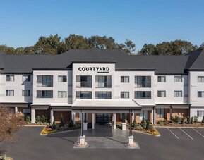 Exterior view of the Courtyard by Marriott hotel building with covered entrance, landscaped grounds and parking spaces at Courtyard By Marriott Dothan.
