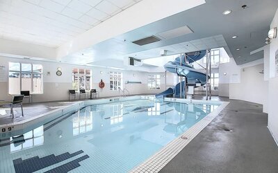 Indoor pool with lounge chairs at Holiday Inn Express & Suites Airport-Calgary.