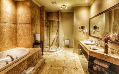 Private guest bathroom with shower and tub at Hotel Brossard.