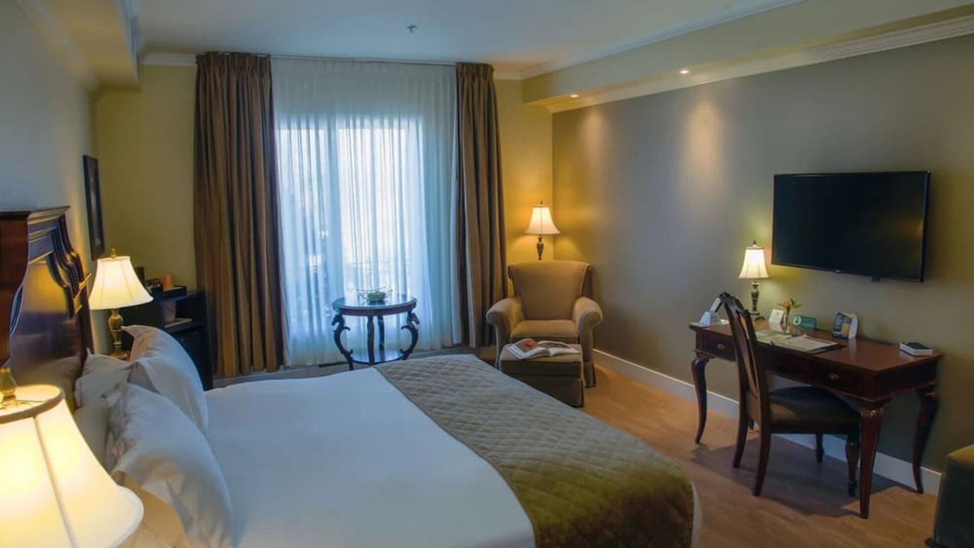 Standard day use room with TV, sofa and work desk at Hotel Brossard.