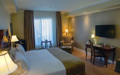 Standard day use room with TV, sofa and work desk at Hotel Brossard.