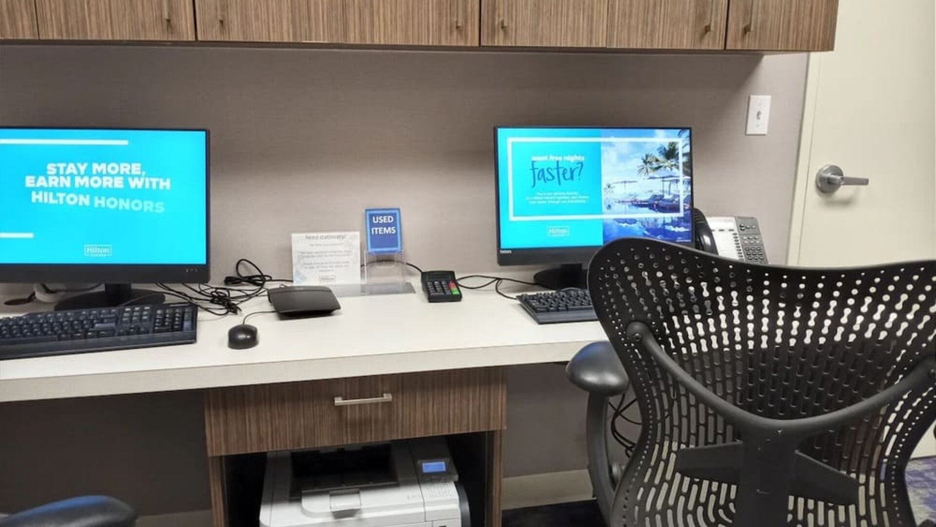 Business center with computers, printer, phone and ergonomic chairs at Hilton Garden Inn Calgary Airport.