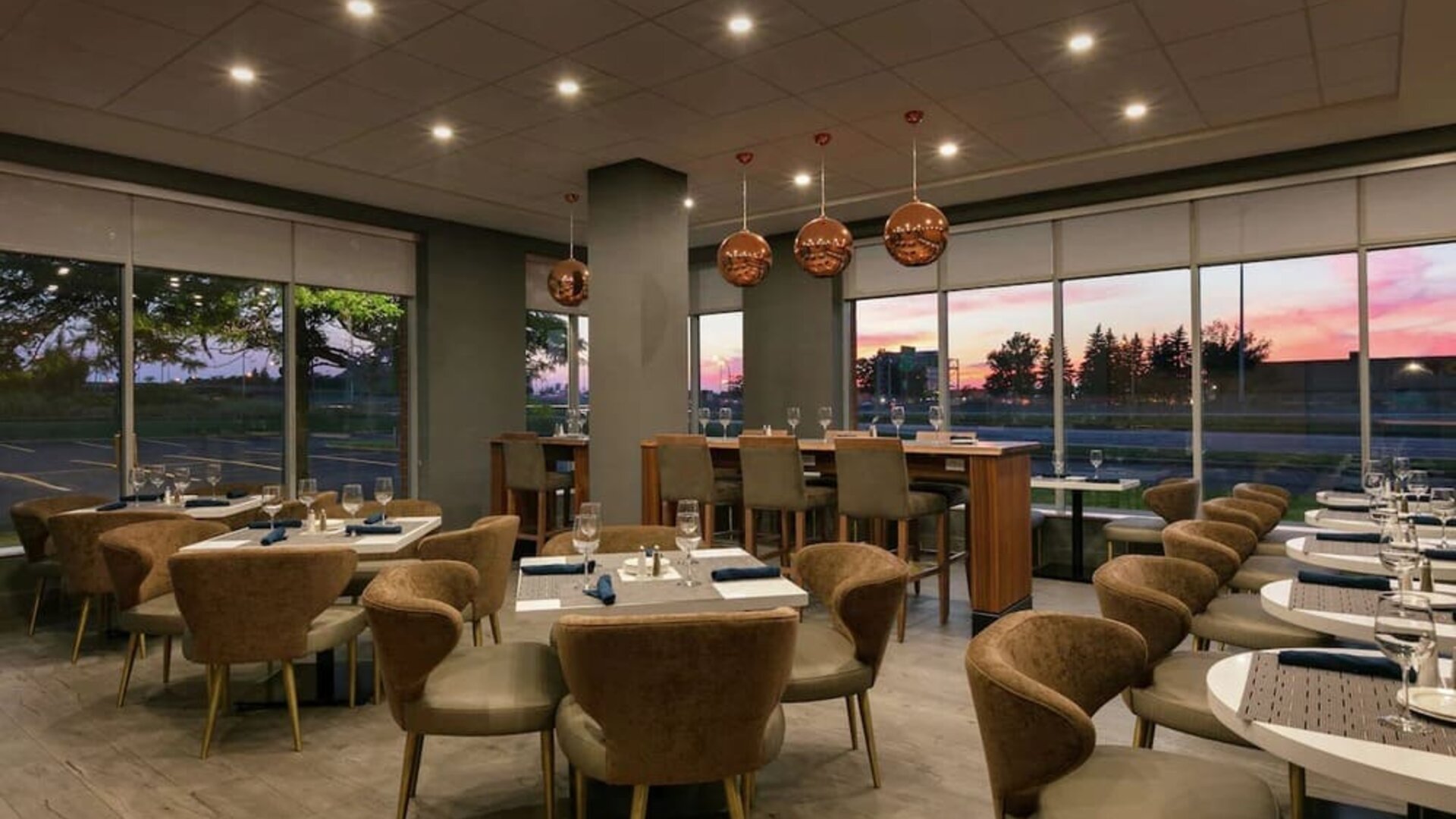 Restaurant area with comfortable seating at the Embassy Suites by Hilton Montreal Airport.