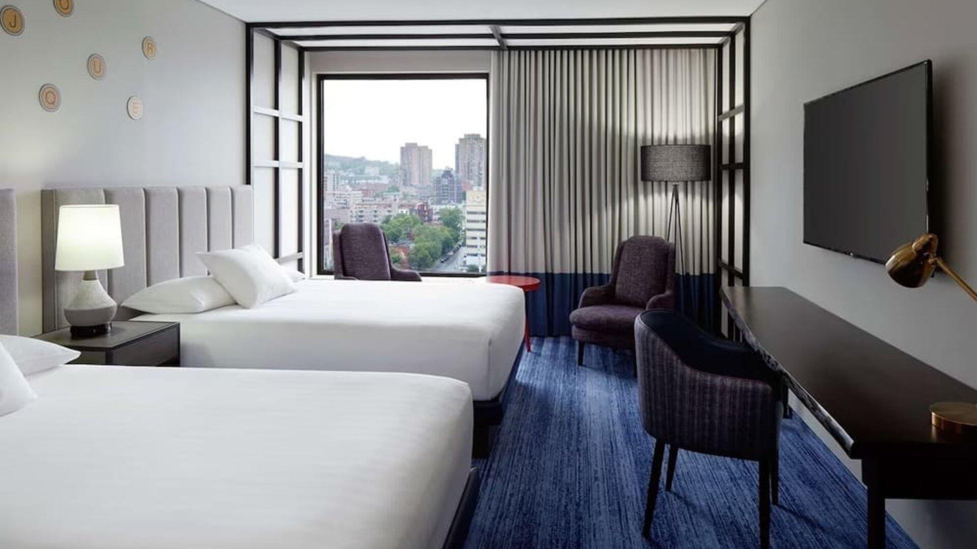 Twin day use room with work desk, lounge area and window view at DoubleTree By Hilton Montreal.