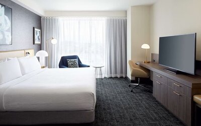 Day use room with king bed, TV, work desk and lounge area at Hilton Garden Inn Montreal Midtown.