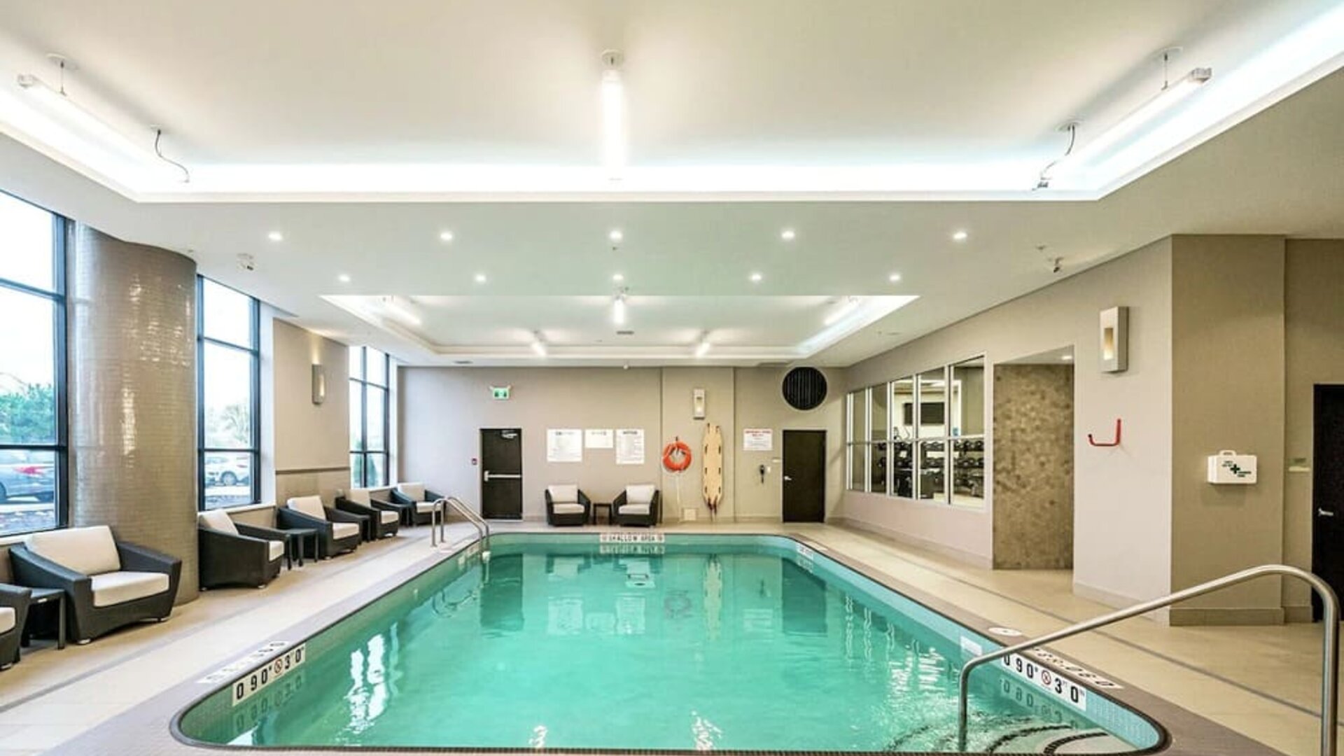 Relaxing indoor pool with lounge chairs at DoubleTree By Hilton Kitchener.