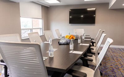 Professional meeting room with TV screen and ergonomic chairs at the Embassy Suites By Hilton Toronto Airport.