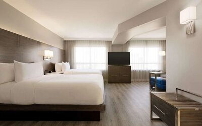 Day use twin room with TV screen, lounge area and work space at the Embassy Suites By Hilton Toronto Airport.