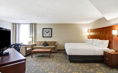 Day use room with TV screen, lounge area, work desk and private bathroom at the Holiday Inn Oakville Centre.