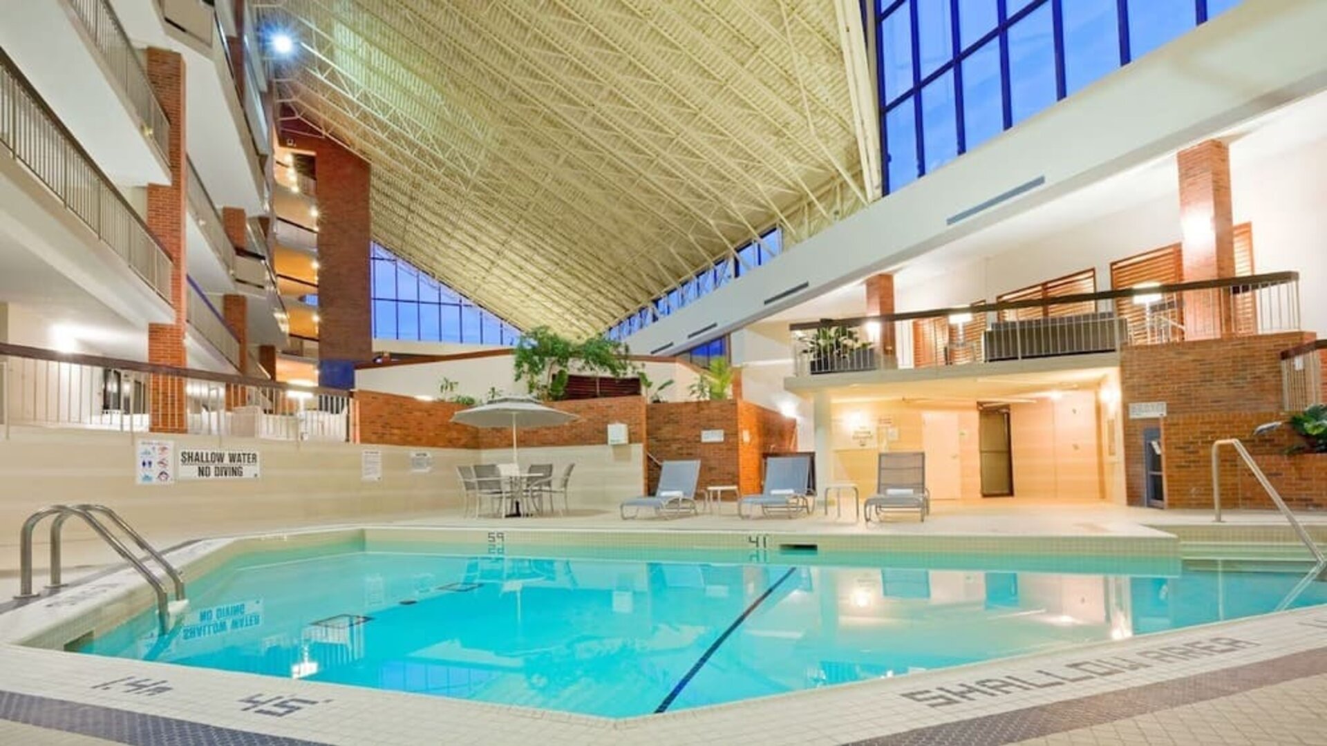 Relaxing indoor pool with lounge chairs at the Holiday Inn Oakville Centre.