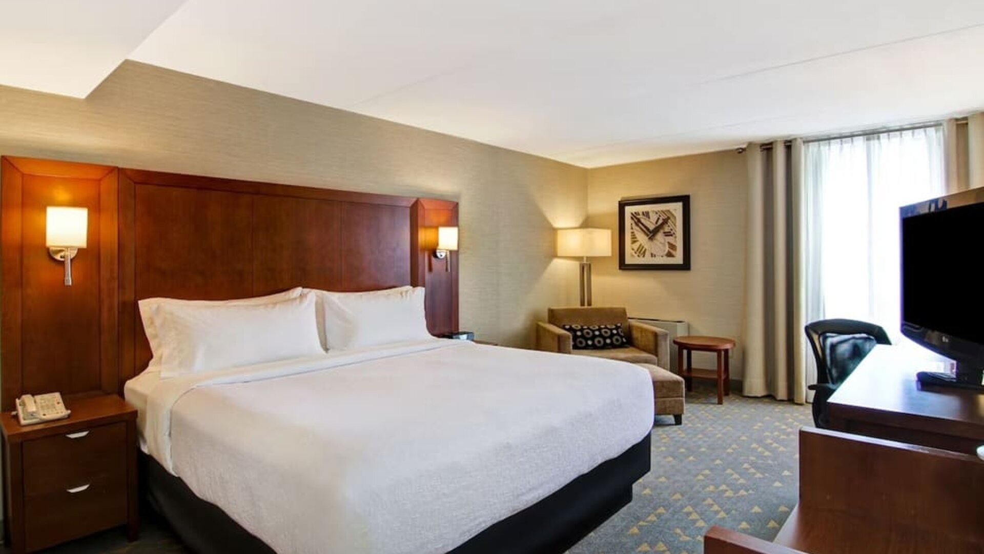 Standard day use room with sofa, TV, work desk and private bathroom at the Holiday Inn Oakville Centre.