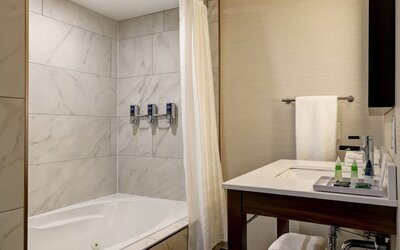 Private guest bathroom with tub and free toiletries at the Four Points By Sheraton St Catharines Niagara Suites.