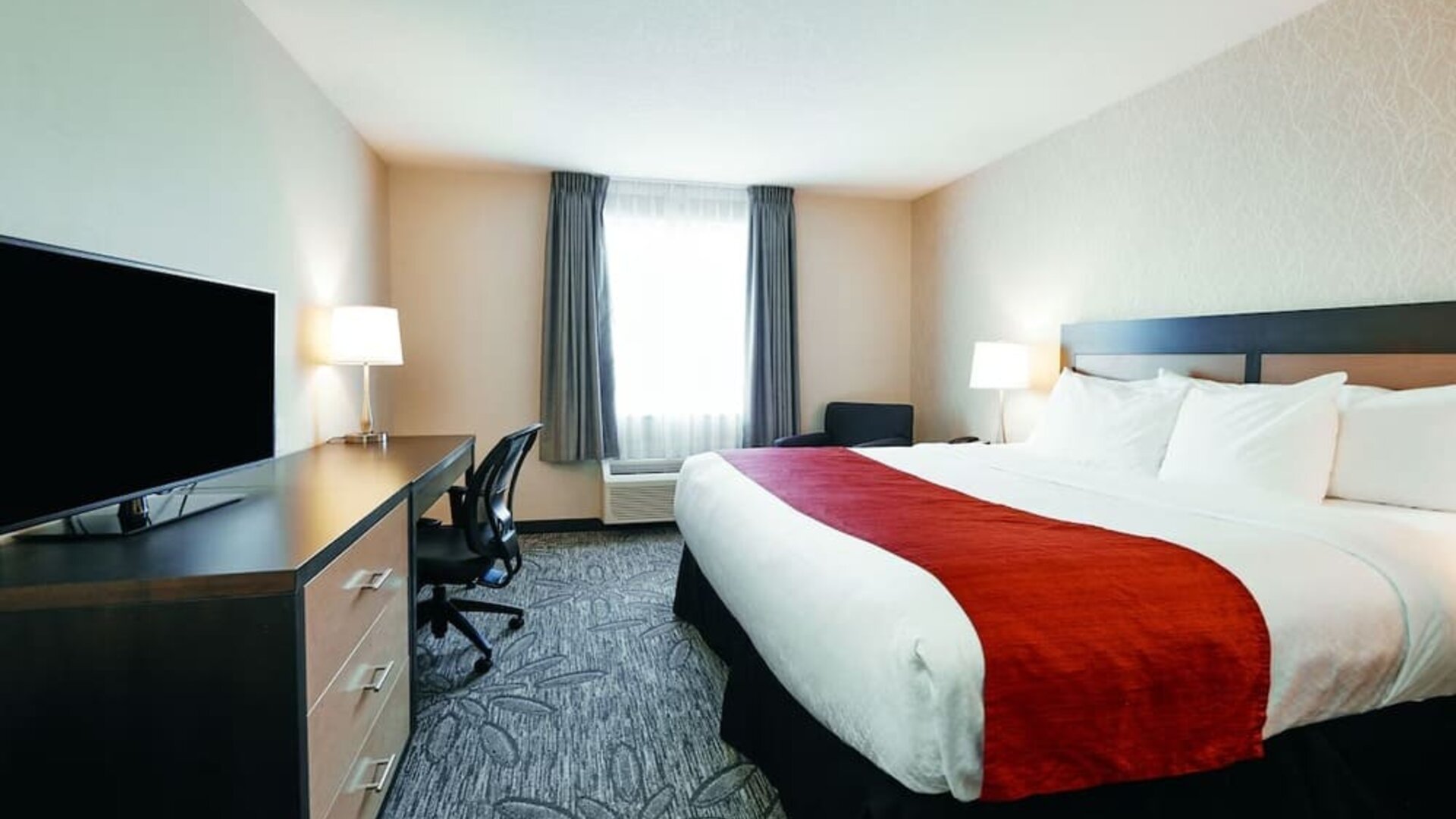 Day use room with TV, sofa, work desk and private bathroom at Quality Inn & Suites Kingston.