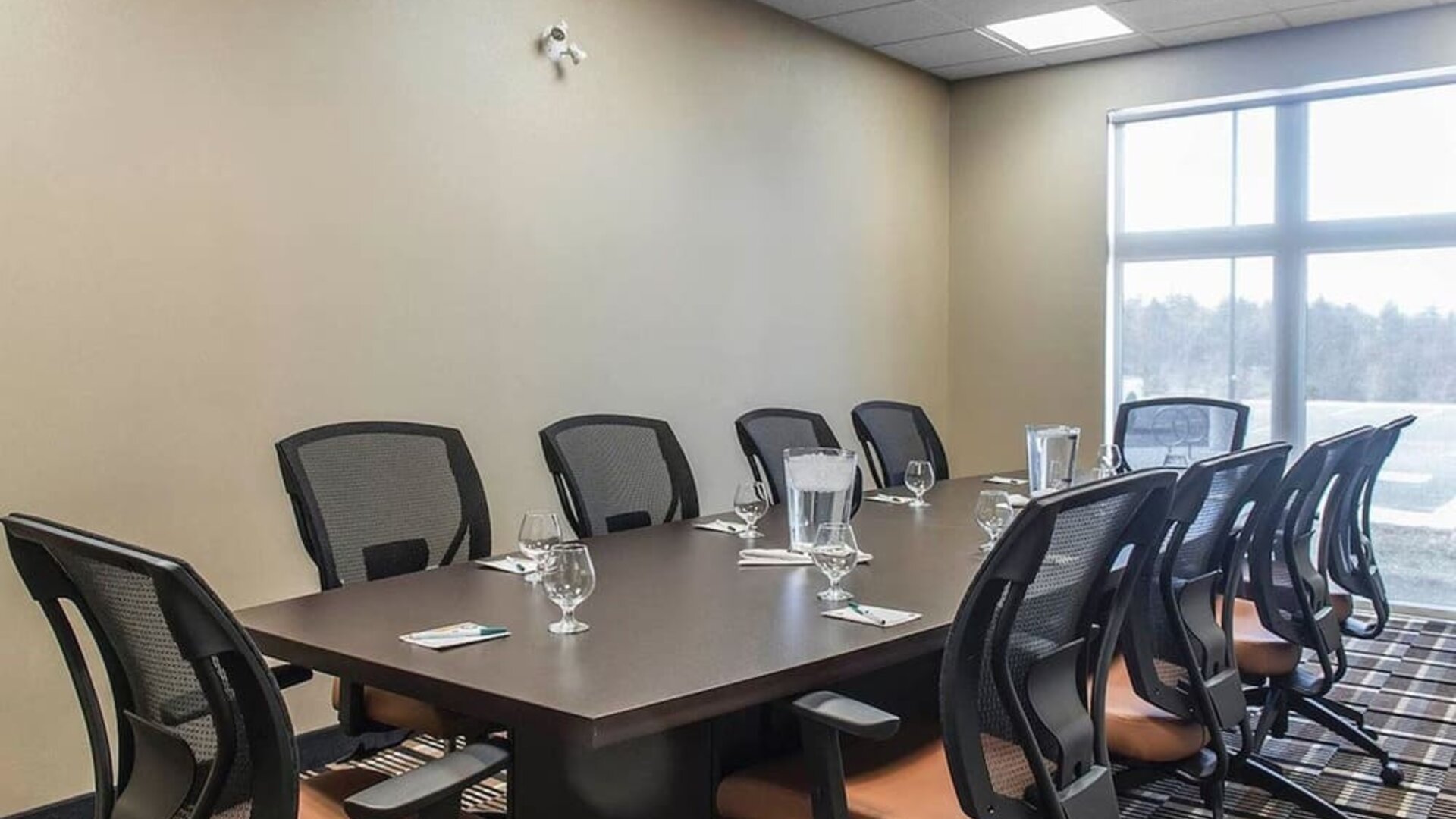 Professional meeting room with large windows and ergonomic chairs at Quality Inn & Suites Kingston.