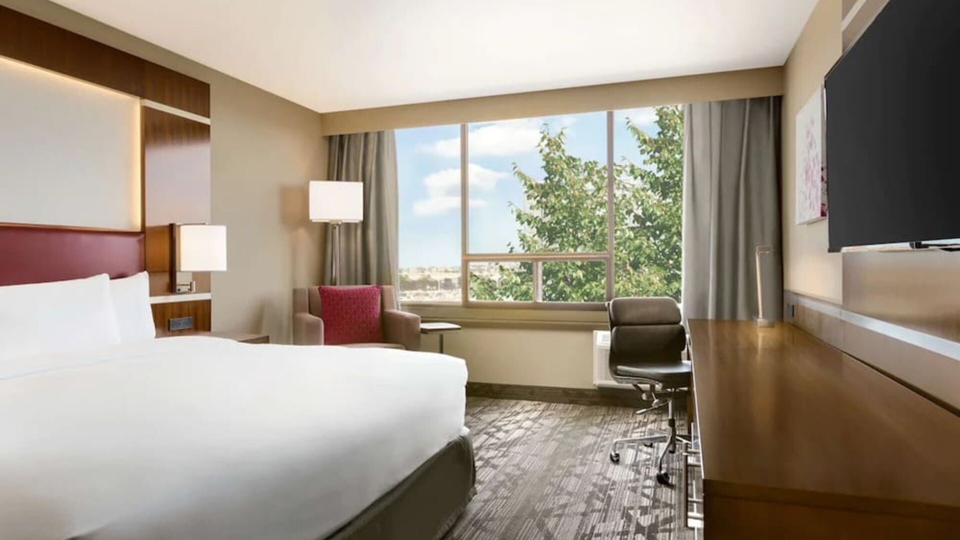 Day use room with large windows, TV, sofa, work desk and private bathroom at DoubleTree By Hilton Hotel Toronto Airport West.