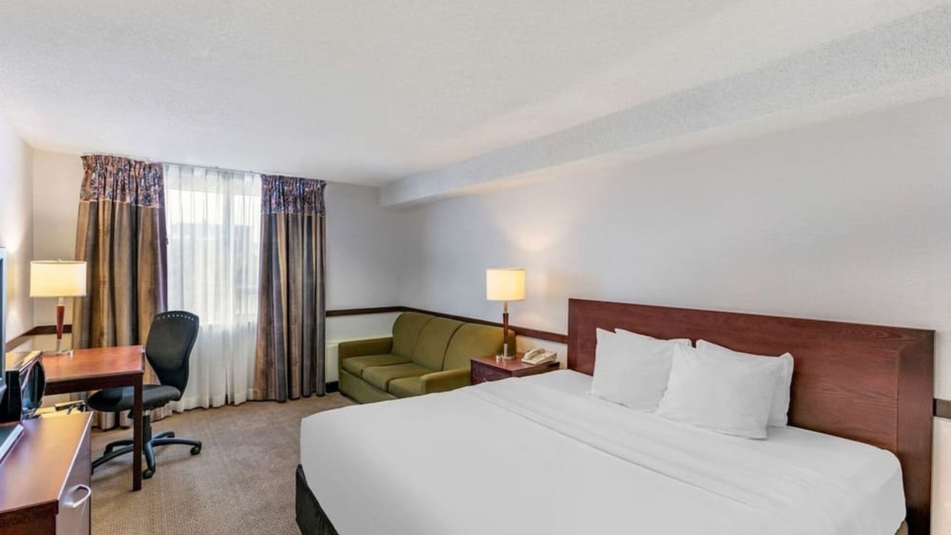 Day use room with TV, sofa, work desk and private bathroom at Quality Hotel & Suites Montreal East.