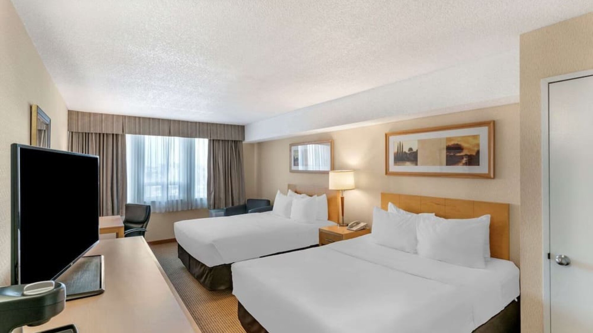 Day use twin room with TV, work desk and private bathroom at Quality Hotel & Suites Montreal East.