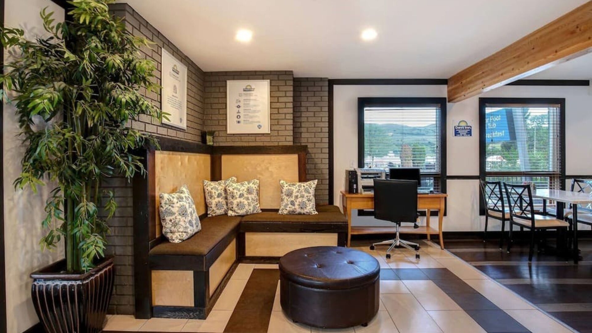 Hotel lobby with lounge area and workspace with computer and printer at Days Inn Vernon.