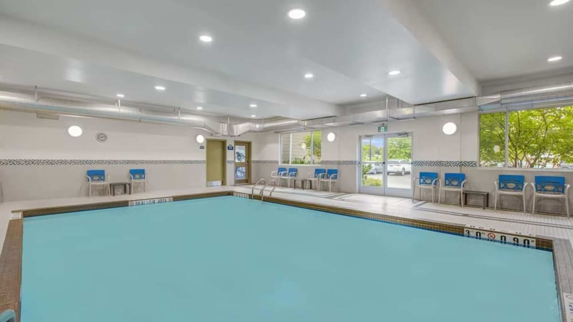 Relaxing indoor pool with lounge chairs at Days Inn & Suites By Wyndham Lindsay.