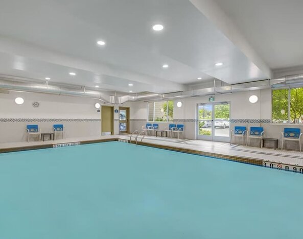 Relaxing indoor pool with lounge chairs at Days Inn & Suites By Wyndham Lindsay.